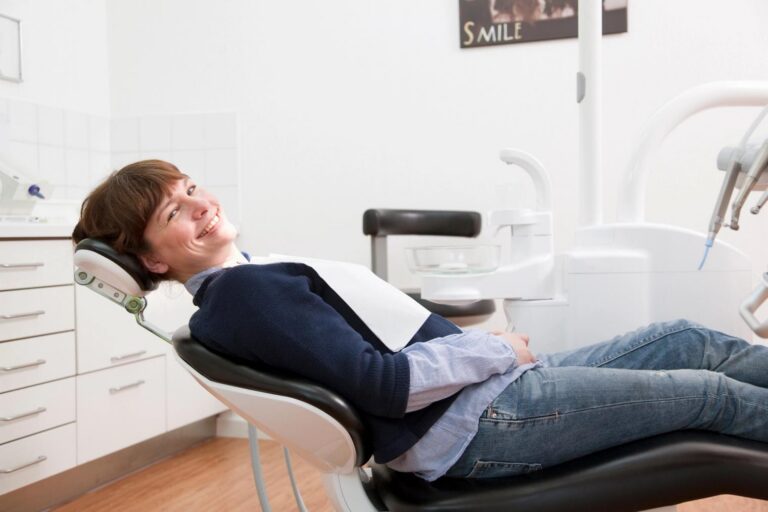 A smiling patient in a dental chair.
