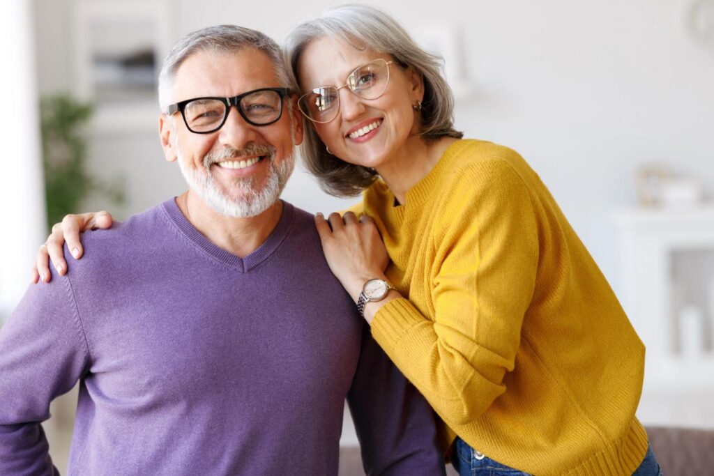 An older couple smiling at the camera.