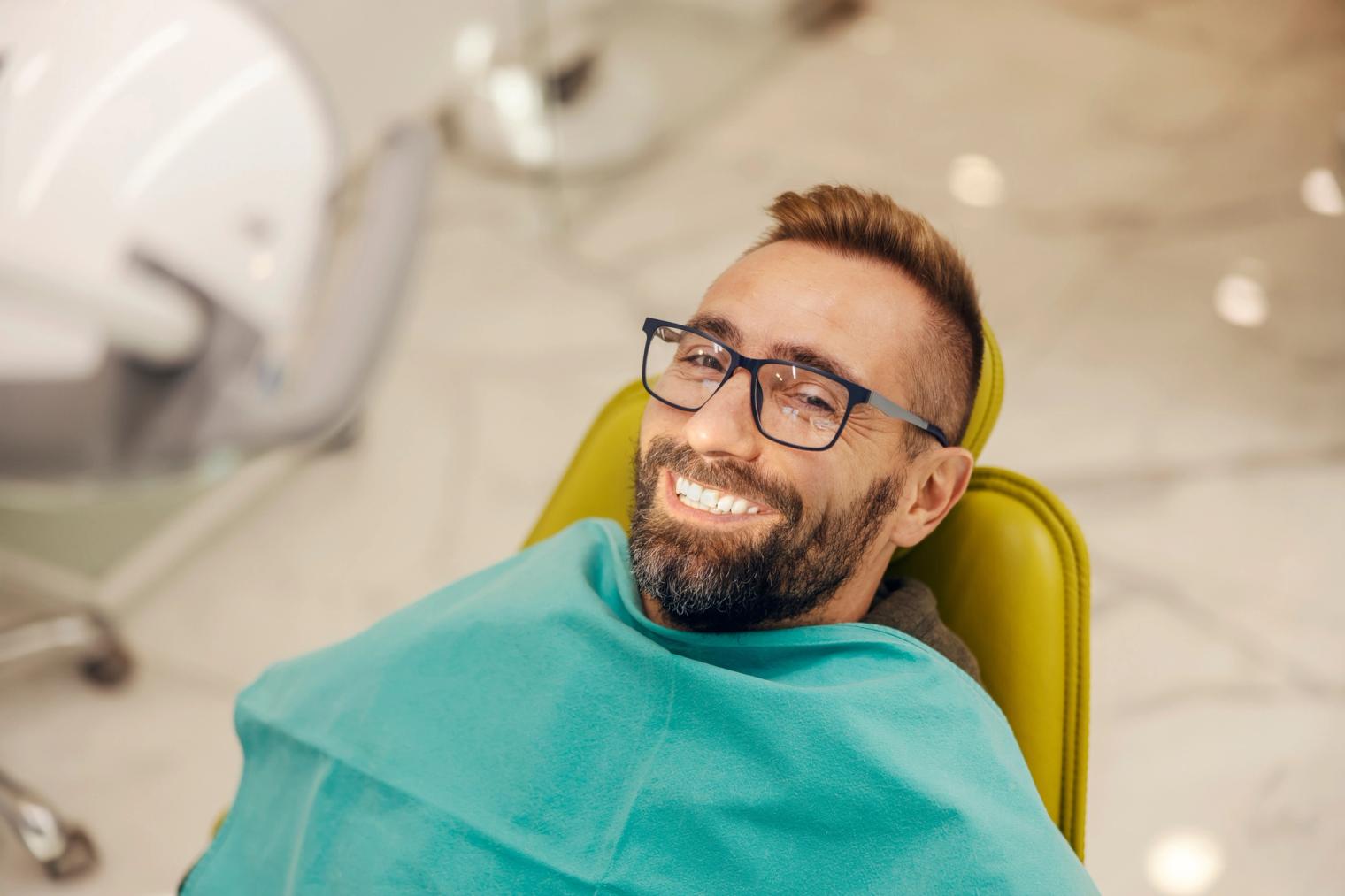A smiling patient seated comfortably in a dental chair